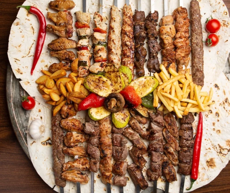 assorted-delicious-grilled-meat-skewers-with-vegetables-french-fries-pita-top-view-min (1)